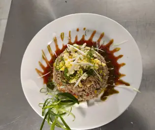 Garnished rice dish with sauce drizzle